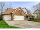 Charming two-story brick home with a three-car garage and well-manicured landscaping at 12512 Geist Cove Dr, Indianapolis, IN 46236