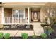 Inviting front porch with white railing and detailed front door, surrounded by manicured landscaping at 12512 Geist Cove Dr, Indianapolis, IN 46236