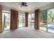 Bright sunroom with large windows, tan drapes, neutral carpet, and a view of the backyard at 12512 Geist Cove Dr, Indianapolis, IN 46236
