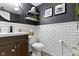 Updated bathroom features a dark accent wall, white subway tile, and a modern vanity with a round mirror at 12612 Clearview Ln, Indianapolis, IN 46236