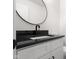 Modern bathroom with granite countertops, sleek hardware, and a stylish round mirror at 1319 Brookside Dr, Columbus, IN 47201
