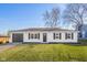 Charming ranch home featuring white siding, black shutters and a well-maintained front lawn, great curb appeal at 1319 Brookside Dr, Columbus, IN 47201