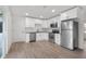Modern kitchen with white cabinets, subway tile backsplash, stainless steel appliances, and wood-look flooring at 1319 Brookside Dr, Columbus, IN 47201