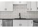 Modern kitchen featuring white cabinets, subway tile backsplash, a stainless steel dishwasher, and black countertop at 1319 Brookside Dr, Columbus, IN 47201