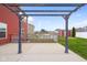 View of back patio with overhead pergola and colorful lights, overlooking backyard chicken run and tool shed at 2016 Woodland Parks Dr, Columbus, IN 47201