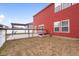 An overview of backyard including a garden, patio with a pergola, and the beautiful red exterior of the home at 2016 Woodland Parks Dr, Columbus, IN 47201