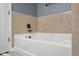 Relaxing bathtub featuring tiled walls and modern fixtures, perfect for unwinding after a long day at 2016 Woodland Parks Dr, Columbus, IN 47201