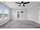 This bedroom features neutral carpet, gray walls, several windows that let in plenty of natural light, and a ceiling fan at 2016 Woodland Parks Dr, Columbus, IN 47201
