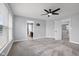This bedroom features neutral carpet, gray walls, several windows that let in plenty of natural light, and a ceiling fan at 2016 Woodland Parks Dr, Columbus, IN 47201