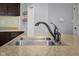 Close up of the double basin kitchen sink and faucet with a light granite countertop and modern fixtures at 2016 Woodland Parks Dr, Columbus, IN 47201