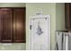 Close up of the pantry door in the kitchen, with adjacent stainless steel refrigerator and ample cabinets at 2016 Woodland Parks Dr, Columbus, IN 47201