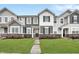 Charming townhomes showcase a landscaped front yard with a brick foundation and gray and white facade at 2171 Mildred Rd, Westfield, IN 46074