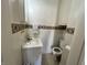 Compact bathroom with a sink, toilet, and wall-mounted storage at 218 S 5Th Ave, Beech Grove, IN 46107