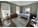 Bright bedroom with hard wood floors, three windows, dresser and comfortable queen bed at 218 S 5Th Ave, Beech Grove, IN 46107