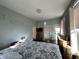 Sunlit bedroom with hard wood floors, window and comfortable queen bed at 218 S 5Th Ave, Beech Grove, IN 46107