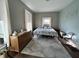 Bright bedroom with hard wood floors, three windows, dresser and comfortable queen bed at 218 S 5Th Ave, Beech Grove, IN 46107