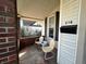 Comfortable covered front porch with brick pillars and seating area, perfect for enjoying the outdoors at 218 S 5Th Ave, Beech Grove, IN 46107