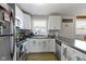 Bright kitchen features white cabinetry, stainless appliances, and durable countertop space for cooking prep at 2230 Mindy Ct, Anderson, IN 46017