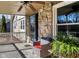 Cozy covered porch with wicker furniture, ceiling fan, and stone detailing, perfect for enjoying the outdoors at 265 Goodnight Rd, Martinsville, IN 46151