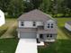Two-story home with gray siding, a two-car garage, and a well-manicured lawn at 3328 Stafford St, Sheridan, IN 46069