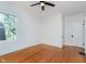 A simple bedroom featuring original hardwood floors, a ceiling fan and a well-lit window at 3750 Totem Ln, Indianapolis, IN 46208