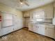 Kitchen featuring laminate flooring, white cabinets, and a vintage ceiling fan at 3751 N Sadlier Dr, Indianapolis, IN 46226