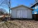 White garage in need of repair with boarded windows, steps with orange railings, and fallen leaves at 396 S Audubon Rd, Indianapolis, IN 46219