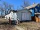 Back of neglected garage with boarded windows, weathered siding, and a wooden staircase with orange railings at 396 S Audubon Rd, Indianapolis, IN 46219