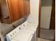 Functional laundry area featuring wood cabinets and a standard washer and dryer set at 424 Wayside Dr, Plainfield, IN 46168
