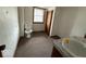 Compact bathroom featuring a toilet, sink, and window, maximizing functionality in a small space at 4534 N State Road 9, Anderson, IN 46012