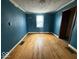 Bright blue bedroom featuring natural light from a window and hardwood floors, creating a vibrant space at 4534 N State Road 9, Anderson, IN 46012
