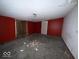 Spacious bedroom with red accent walls and a closet door, offering potential for customization at 4534 N State Road 9, Anderson, IN 46012