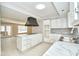 Bright kitchen features marble counters, custom cabinets, island cooktop and oversized vent at 493 N Avon Ave, Avon, IN 46123