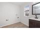 Bathroom featuring dark wood vanity with black fixtures, a window, and laundry hook-ups at 5004 Boardwalk Pl, Indianapolis, IN 46220