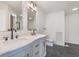 Well lit bathroom featuring double sinks, an elegant vanity, and a modern toilet at 5004 Boardwalk Pl, Indianapolis, IN 46220