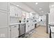 Galley kitchen with white cabinetry, stainless steel appliances, and wood-look floors throughout at 5004 Boardwalk Pl, Indianapolis, IN 46220
