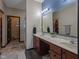 Bathroom featuring double sinks with marble countertops, dark wood cabinets, and a modern lighting fixture at 553 Farnham Dr, Westfield, IN 46074