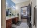 Bathroom featuring double sinks with marble countertops, a dark wood cabinet, and an open view to the main bedroom at 553 Farnham Dr, Westfield, IN 46074