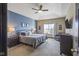 Comfortable bedroom with neutral tones, featuring a ceiling fan, tray ceiling, and ample natural light at 553 Farnham Dr, Westfield, IN 46074