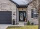 Charming entryway with decorative wreath, black framed front door, sidelight window, and gray brick exterior at 553 Farnham Dr, Westfield, IN 46074