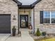 Charming entryway with decorative wreath, black framed front door, sidelight window, and gray brick exterior at 553 Farnham Dr, Westfield, IN 46074