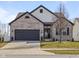 Charming two-story home featuring a grey brick facade, dark trim, a manicured lawn, and a two-car garage at 553 Farnham Dr, Westfield, IN 46074