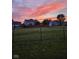 Expansive backyard with a secure fence, offering privacy and a safe play area, all under a beautiful, colorful sky at 5772 Jamestown Square Ln, Indianapolis, IN 46234
