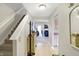 Hallway with tiled floor leading to carpeted stairs and an open view of the kitchen and living area at 5772 Jamestown Square Ln, Indianapolis, IN 46234