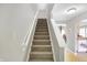 Carpeted staircase with a white railing connecting to the upper floors with easy access to living spaces at 5772 Jamestown Square Ln, Indianapolis, IN 46234