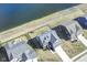A high aerial view captures a two-story home adjacent to a pond with a patio and firepit in the landscaped backyard at 6199 N Caraway Dr, McCordsville, IN 46055