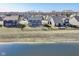 An aerial view displays several two-story homes backing to a pond with fenced yards and neighborhood in the background at 6199 N Caraway Dr, McCordsville, IN 46055