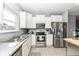 Well-equipped kitchen with stainless steel appliances, bright cabinets, and spacious tile flooring at 6199 N Caraway Dr, McCordsville, IN 46055
