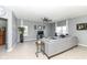 Bright living room with neutral paint, ceiling fan, tile flooring, and comfortable gray sectional sofa at 6199 N Caraway Dr, McCordsville, IN 46055
