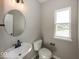 Modern bathroom featuring round mirror, vanity, and toilet at 6323 Willow Branch Way, Plainfield, IN 46168